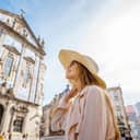 A young female tourist stands near the Congregados Church, adorned with Portugal's famous blue tiles.