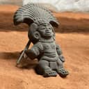 Native American clay figurine displayed on sand