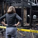 woman looks at a burned down house