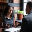 African applicant answer questions at job interview meeting in cafe with employer