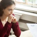Nervous stressed female applicant waiting for result at hiring negotiations, insecure woman candidate feeling worried while hr managers read discuss her cv resume, bad failed job interview concept