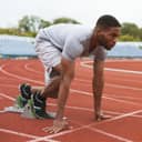 Man gets ready to run on a running track.