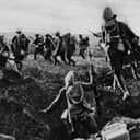 Vintage photograph from The Great War showing troops charging out of a trench