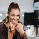 Beauty vlogger recording a makeup tutorial in a well lit room and showing off the lip pencil she was using