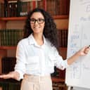 a female tutor teaching English and pointing at grammar rules on a board