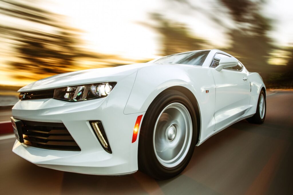 A white sports car driving at a fast speed