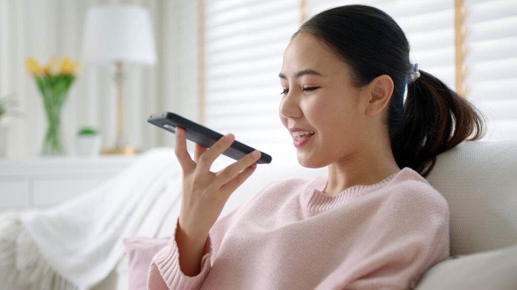 A young woman using an AI chatbot on her phone to study English